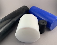 Uncut rods of blue, black, and white delrin